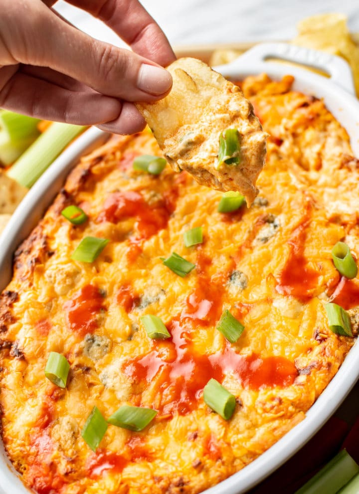 a chip being dipped into hot buffalo chicken dip