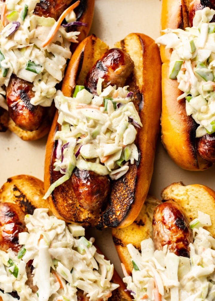 close-up of a pile of Cajun beer brats (in buns with coleslaw)
