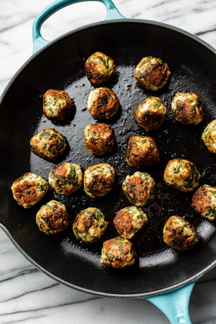 skillet filled with chicken spinach meatballs