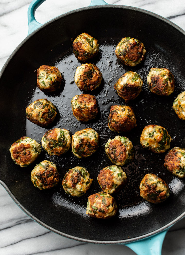 skillet filled with chicken spinach meatballs
