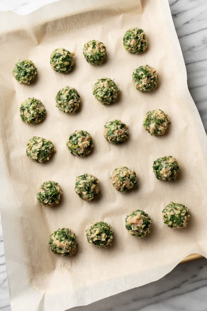 chicken and spinach meatballs on a baking sheet
