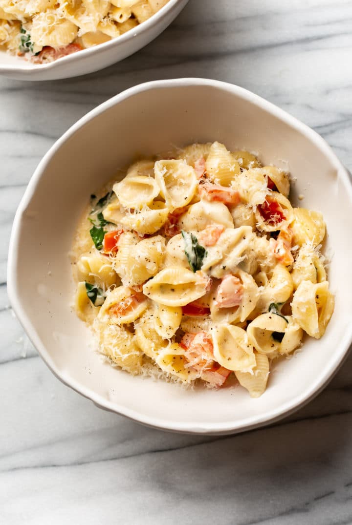 creamy tomato basil pasta in two white bowls (shell pasta)