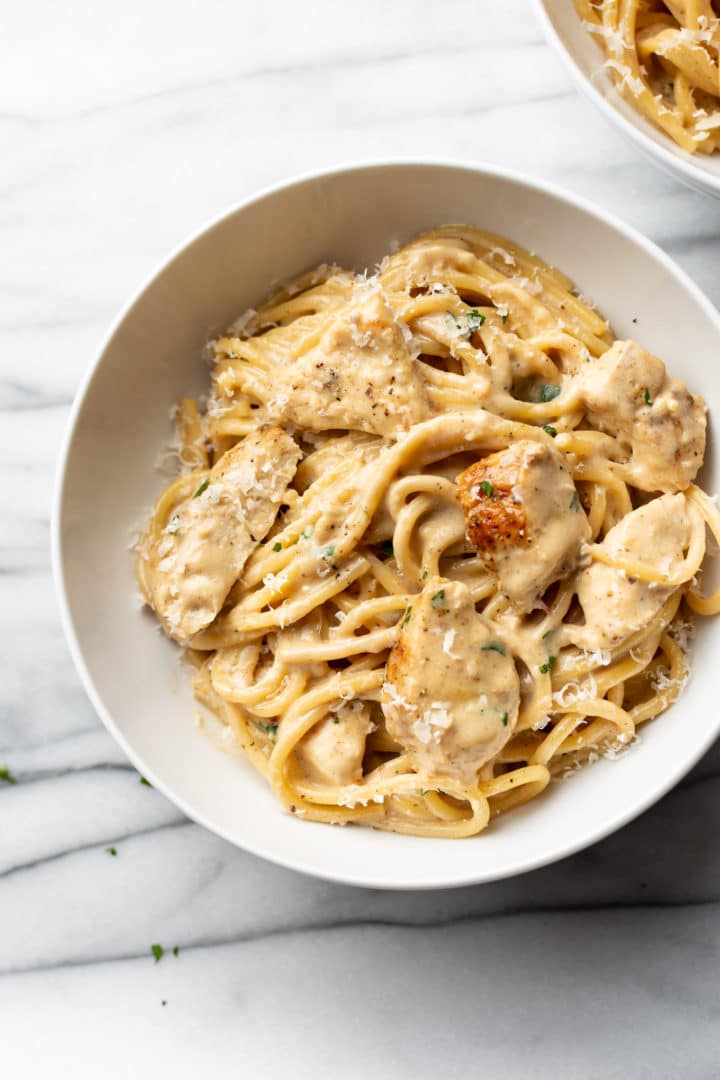 creamy garlic chicken pasta in a white bowl