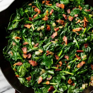 sauteed spinach with bacon in a cast iron skillet