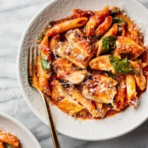 spicy chicken pasta in two shallow bowls