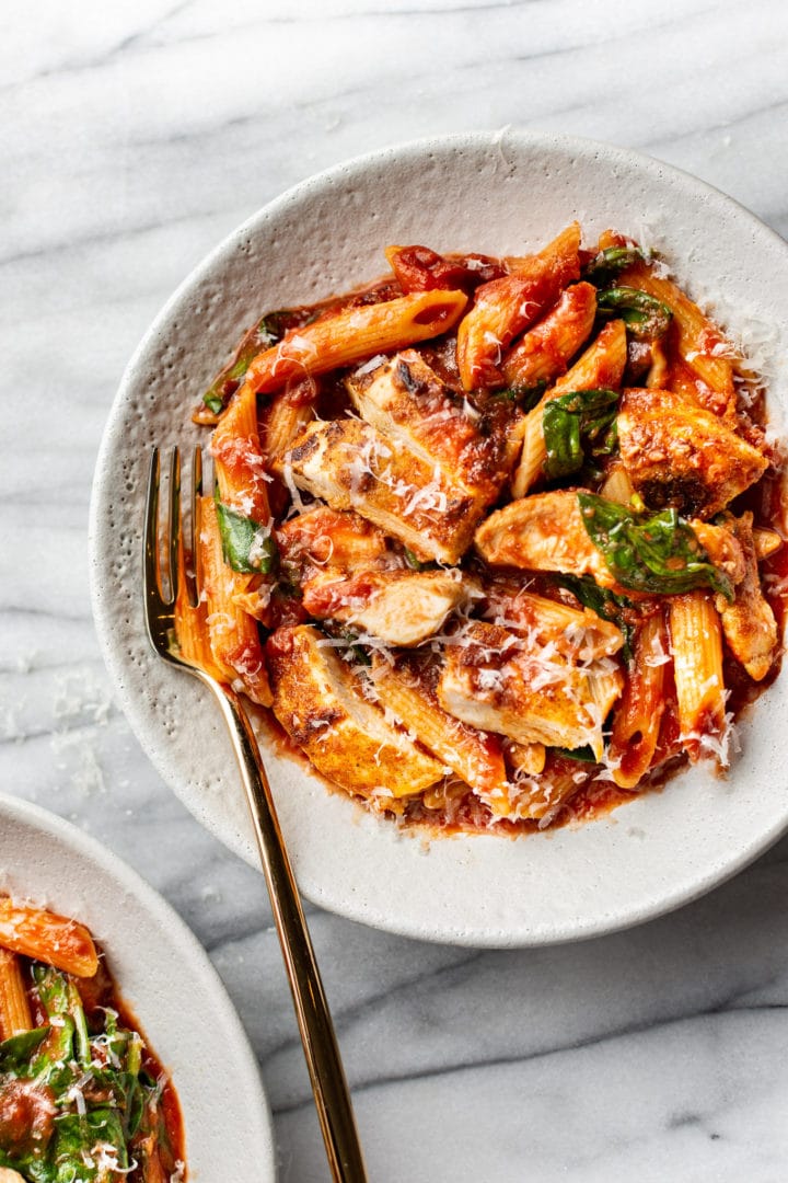 spicy chicken pasta in two shallow bowls
