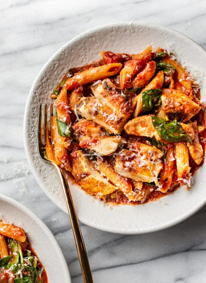 spicy chicken pasta in two shallow bowls