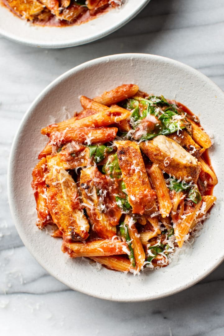 close-up of spicy chicken pasta with penne in a shallow bowl