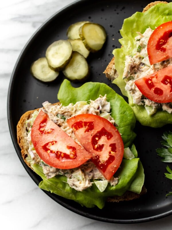 canned mackerel salad on open faced sandwiches with lettuce and tomato on a plate