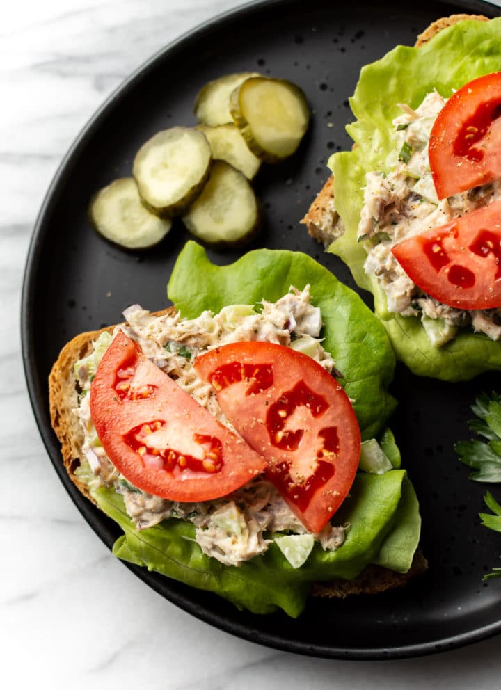 canned mackerel salad on open faced sandwiches with lettuce and tomato on a plate