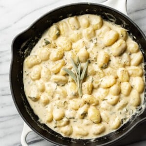 creamy sage gnocchi in a white Le Creuset skillet