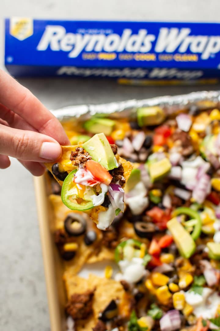 close-up of a female hand grabbing a nacho