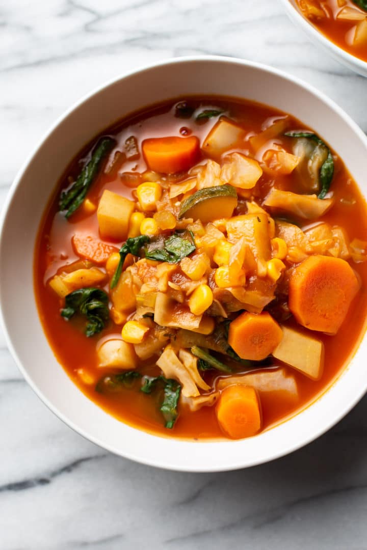 vegetable soup with cabbage in two white bowls