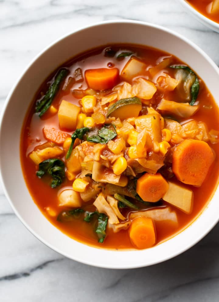 vegetable soup with cabbage in two white bowls