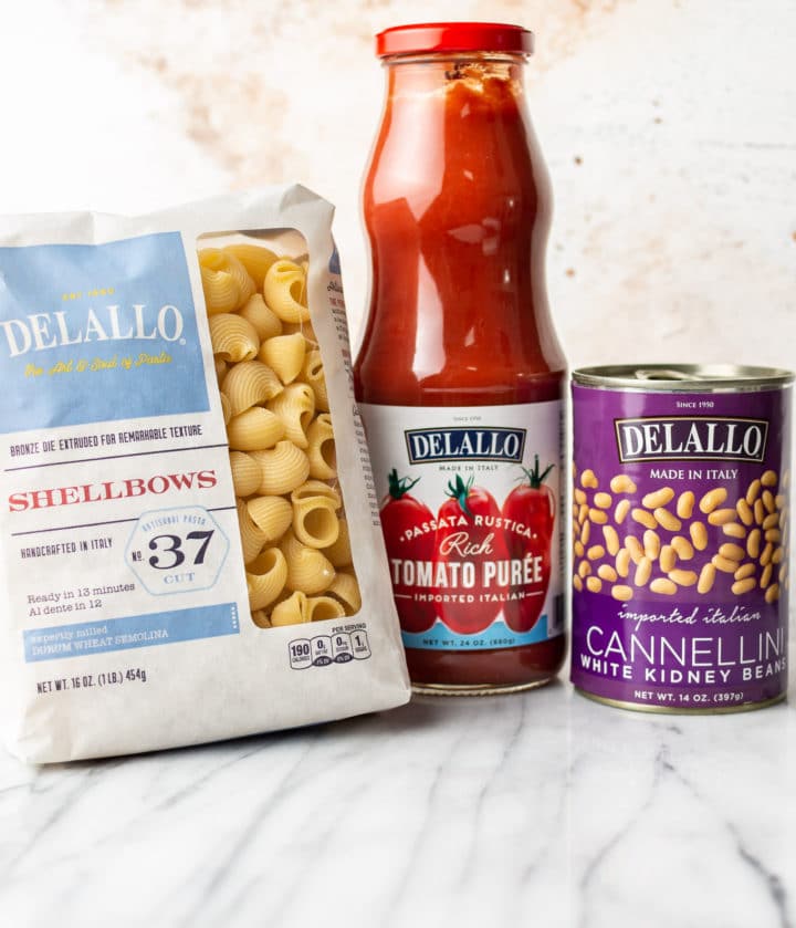 DeLallo shellbows, passata, and cannellini beans on a marble background