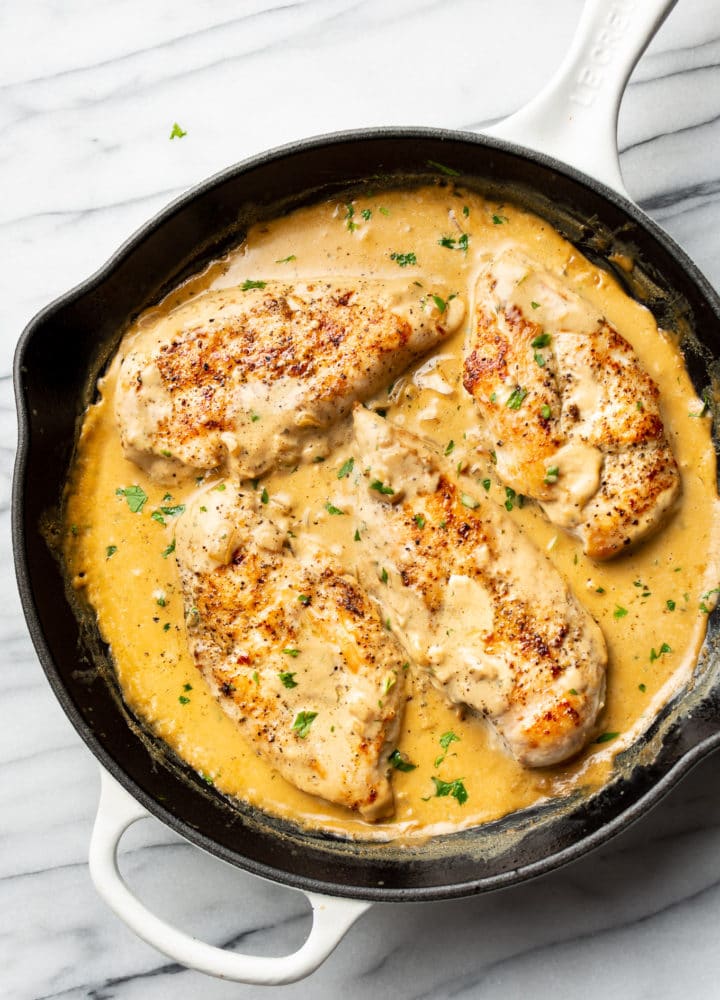 creamy Boursin chicken in a white cast iron skillet