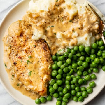 Boursin chicken plated with peas and mashed potatoes