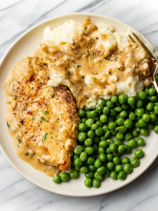 Boursin chicken plated with peas and mashed potatoes