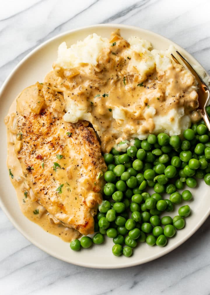 Boursin chicken plated with peas and mashed potatoes