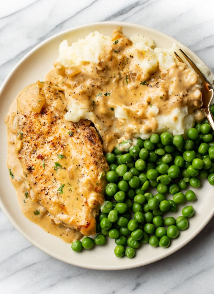 Boursin chicken plated with peas and mashed potatoes