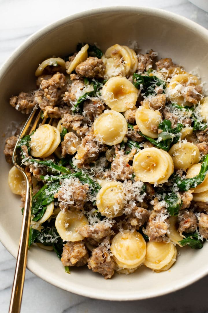 orecchiette pasta with sausage and spinach close-up in a bowl