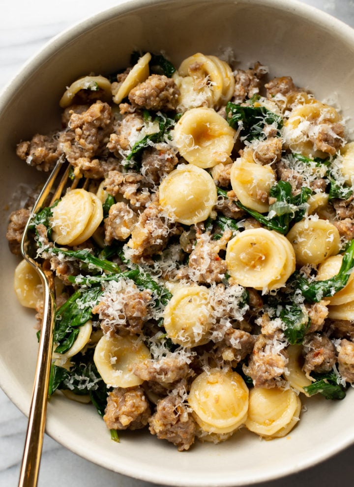 orecchiette pasta with sausage and spinach close-up in a bowl