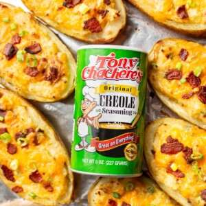 Tony Chachere's Original Creole Seasoning surrounded by twice baked potatoes on a baking sheet