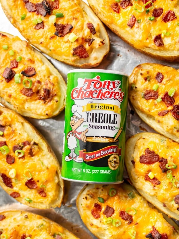 Tony Chachere's Original Creole Seasoning surrounded by twice baked potatoes on a baking sheet