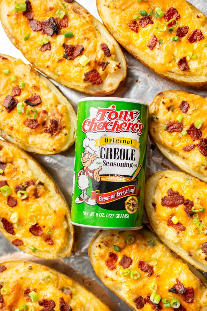 Tony Chachere's Original Creole Seasoning surrounded by twice baked potatoes on a baking sheet