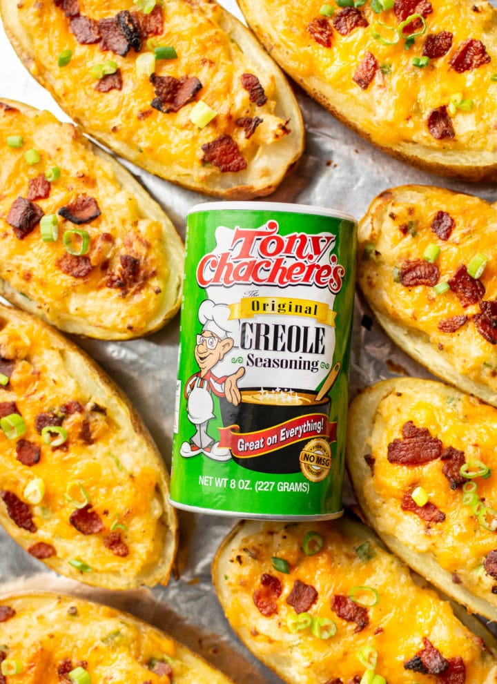 Tony Chachere's Original Creole Seasoning surrounded by twice baked potatoes on a baking sheet