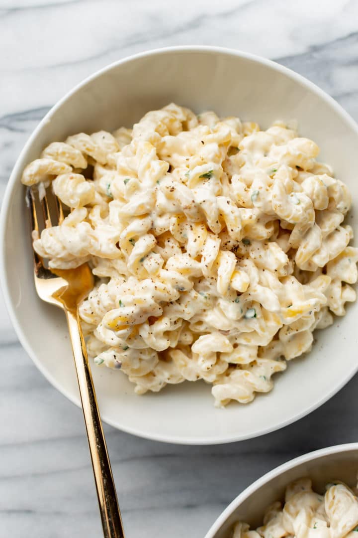 bowl of cream cheese pasta with a gold fork