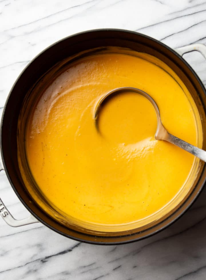 sweet potato soup in a pot with a ladle