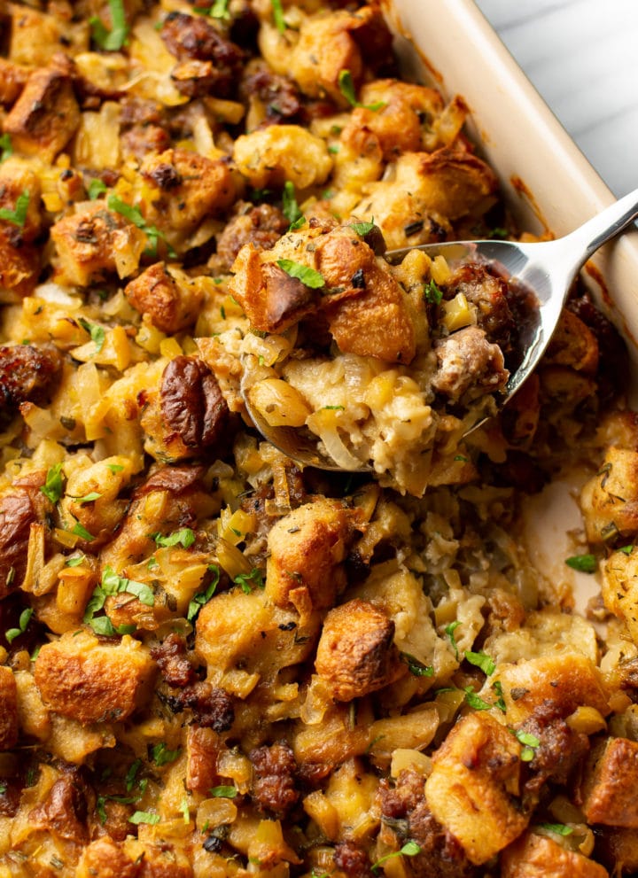 close-up of a spoonful of sausage stuffing in a casserole dish