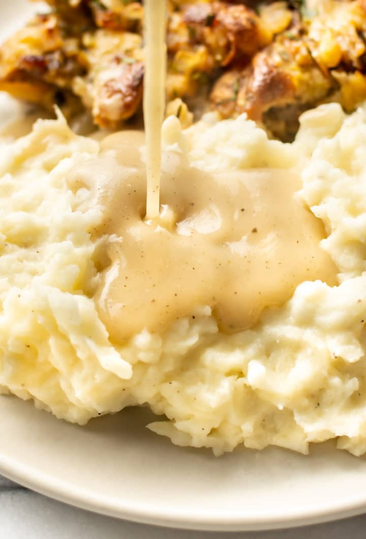 turkey gravy being poured onto mashed potatoes