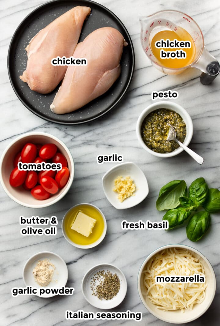 ingredients for pesto chicken prepped in bowls on a marble surface