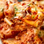 close-up of a metal spatula with a serving of cheesy baked ziti