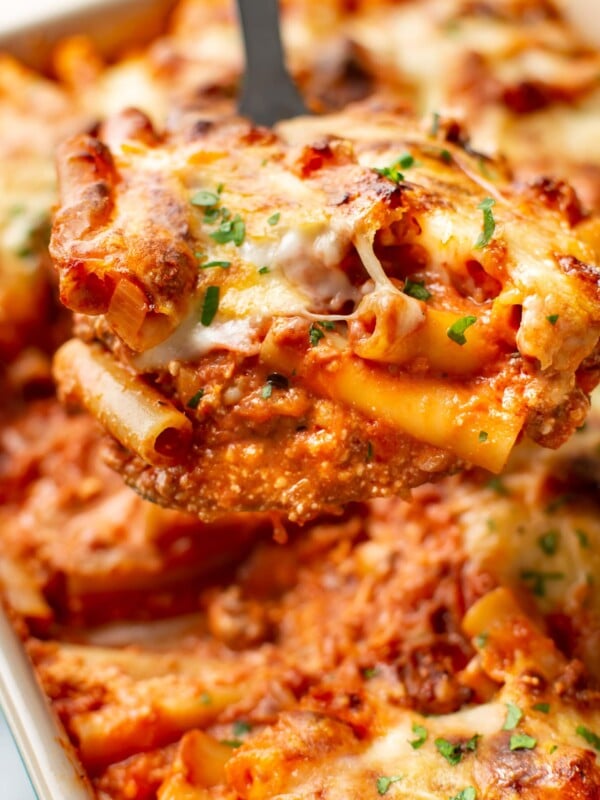 close-up of a metal spatula with a serving of cheesy baked ziti