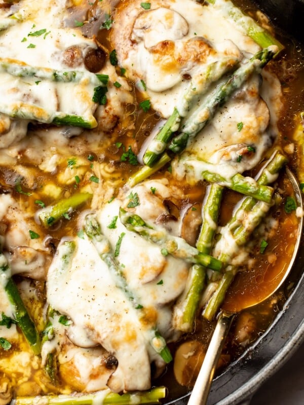 close-up of a skillet with chicken madeira and a serving spoon