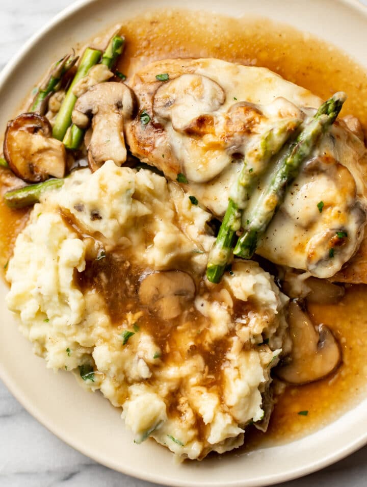 close-up of a plate with chicken madeira, asparagus, and mashed potatoes