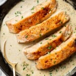 a cast iron skillet with creamy garlic salmon