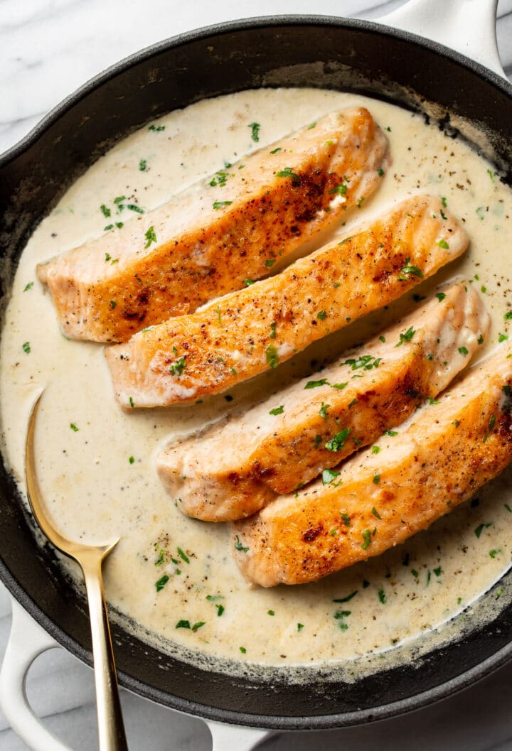 a cast iron skillet with creamy garlic salmon