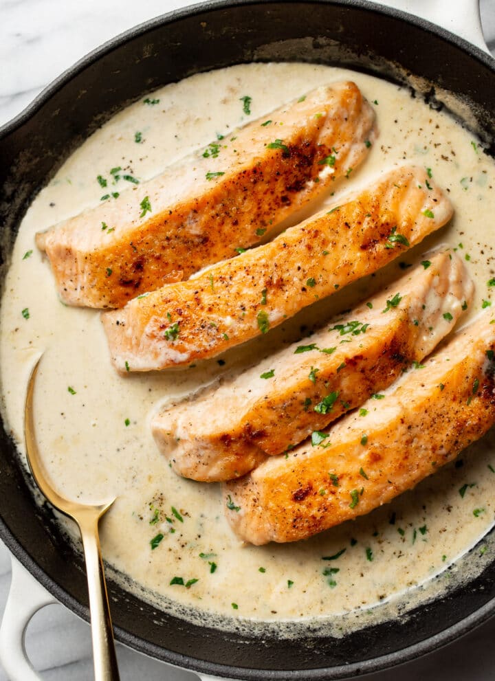 a cast iron skillet with creamy garlic salmon