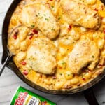 a cast iron skillet with cajun chicken and gnocchi next to a jar of tony chachere seasoning