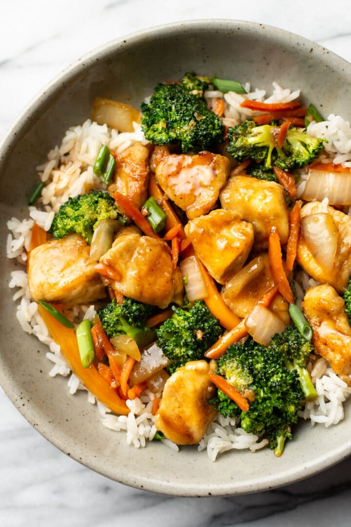 a bowl of chicken stir fry over rice