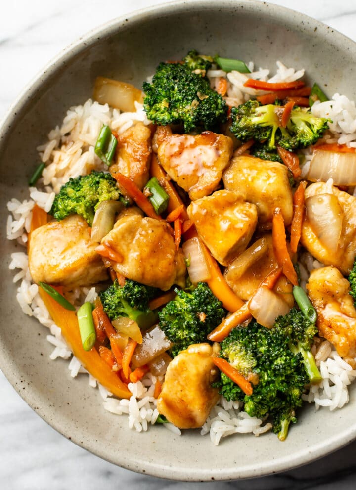 a bowl of chicken stir fry over rice