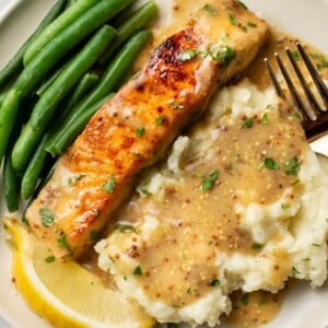 a plate with honey mustard salmon, mashed potatoes, and green beans