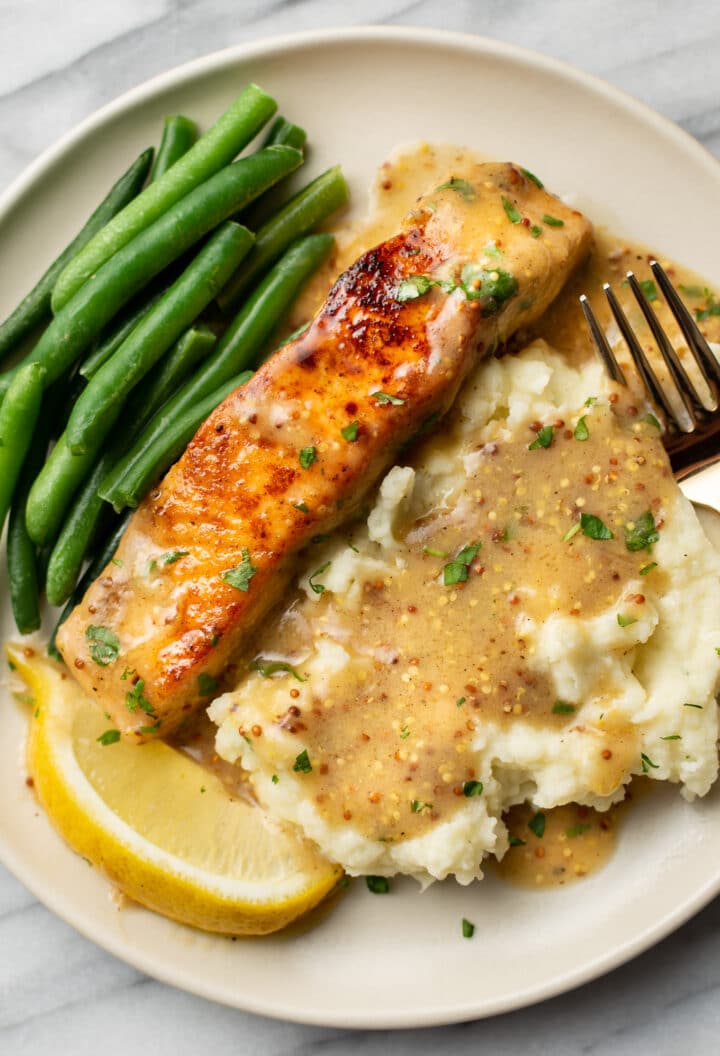 a plate with honey mustard salmon, mashed potatoes, and green beans