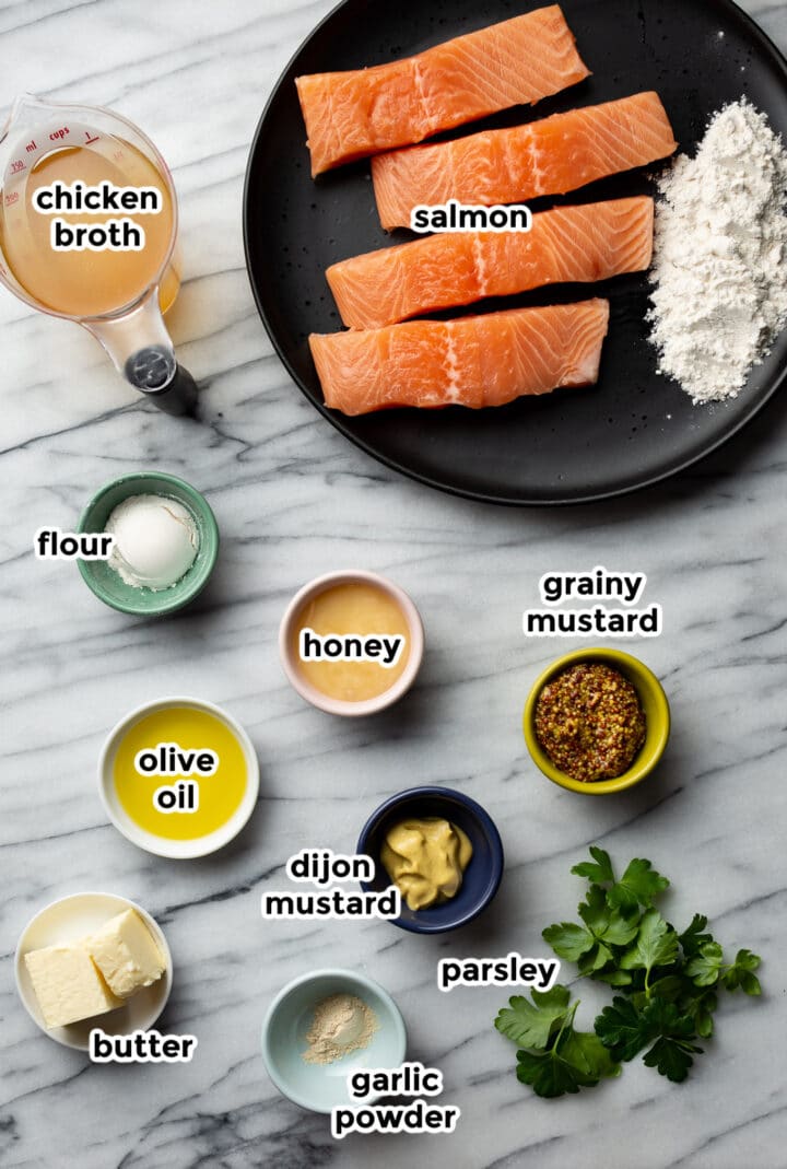 ingredients for honey mustard salmon in small bowls on a marble surface
