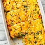 a casserole dish with sausage breakfast casserole with a piece removed