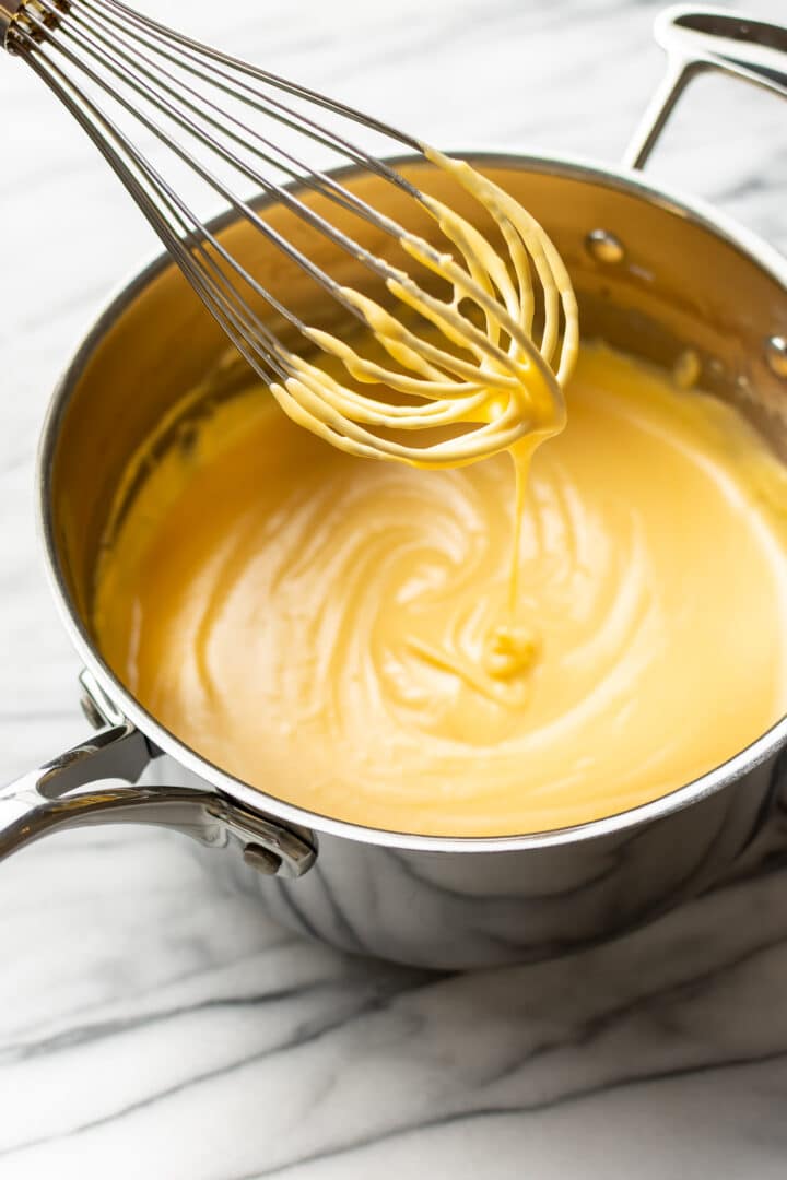 a whisk with cheese sauce on it